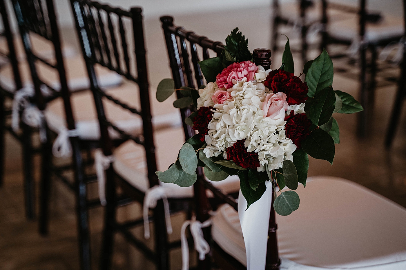Ceremony chair with red pink and white floral decoration Romantic Winter Wedding captured NYC Wedding Planner Poppy and Lynn