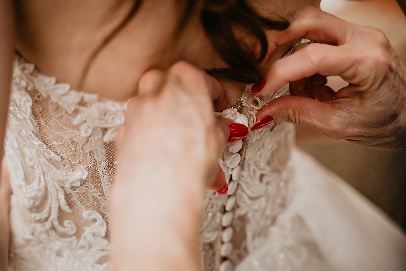 Closeup shot of mother of Bride helping button up Laced Wedding Dress Romantic Winter Wedding captured NYC Wedding Planner Poppy and Lynn