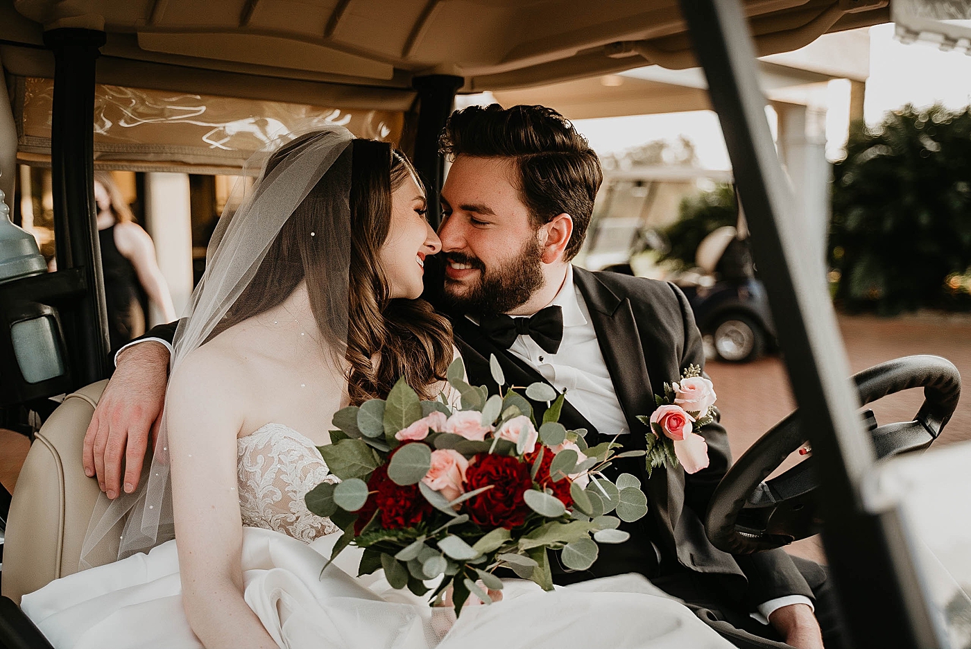 Bride and Groom about to kiss on golf cart with red accent bouquet Romantic Winter Wedding captured NYC Wedding Planner Poppy and Lynn