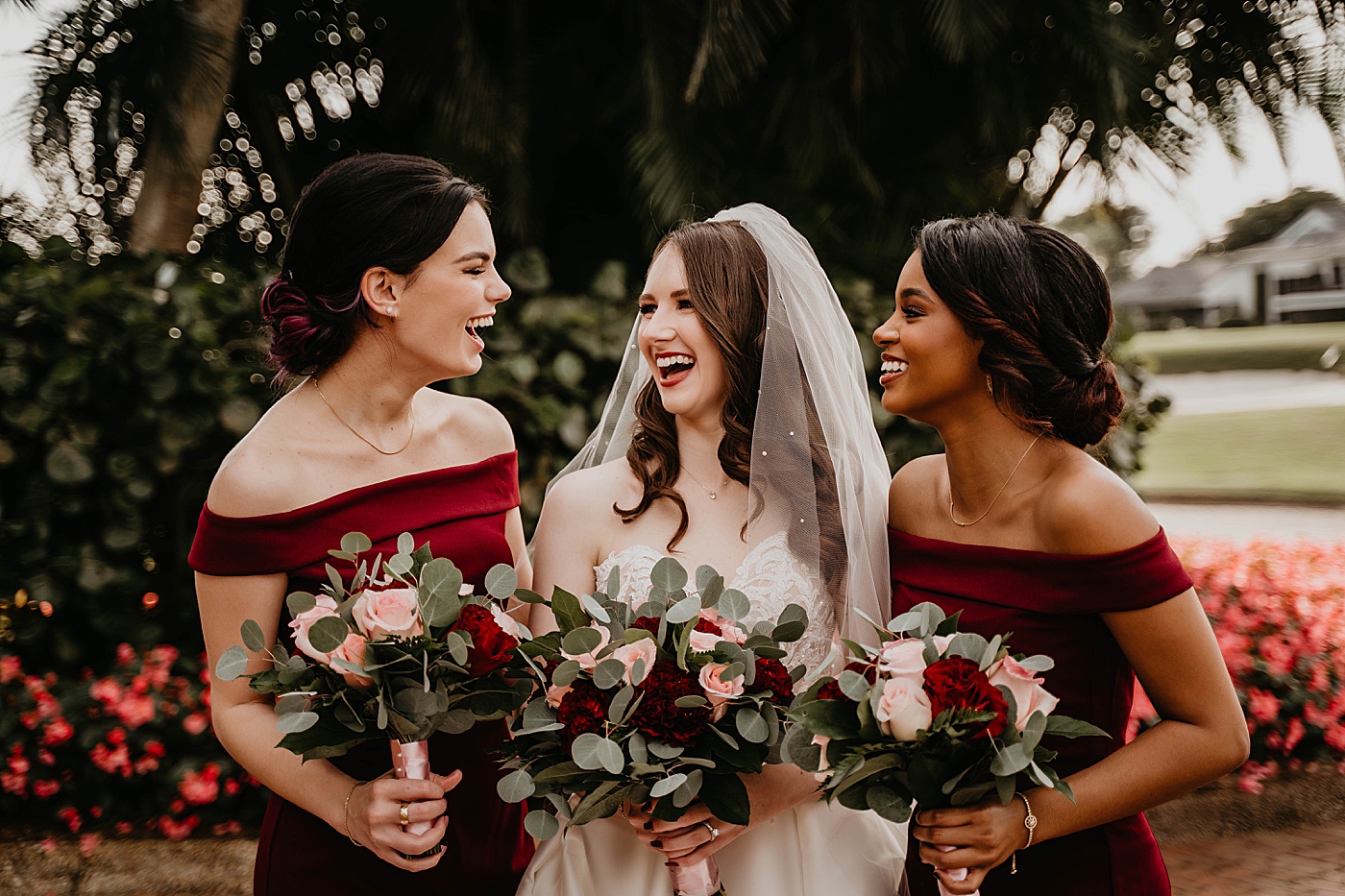 Bride and Bridesmaids laughing outside by red flower patch on golf course Romantic Winter Wedding captured NYC Wedding Planner Poppy and Lynn