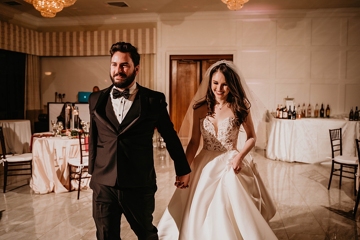 Bride and Groom entering First Dance at Ceremony with bar behind them Romantic Winter Wedding captured NYC Wedding Planner Poppy and Lynn