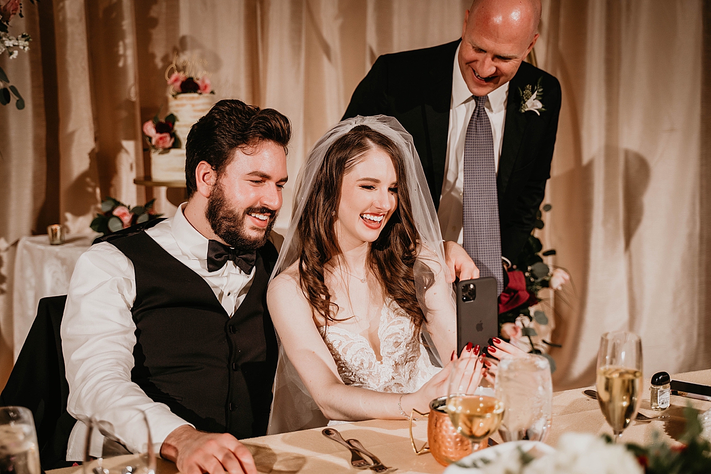 Bride Groom and father of Bride Facetiming Zooming with family on wedding day at sweetheart table Romantic Winter Wedding captured NYC Wedding Planner Poppy and Lynn