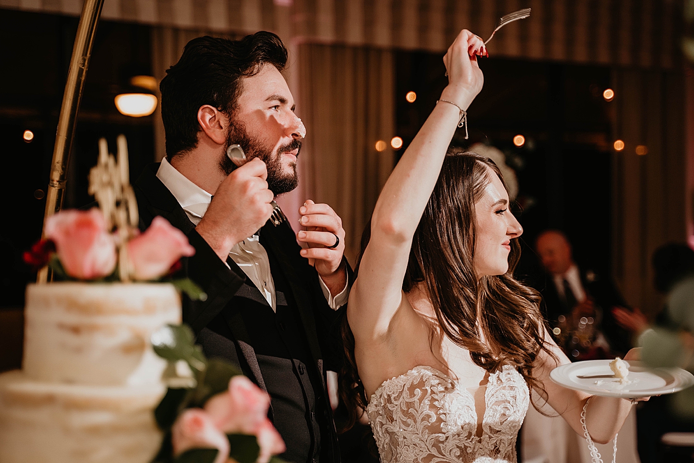 Bride and Groom celebrating after messy cake bite cake cutting at Reception Romantic Winter Wedding captured NYC Wedding Planner Poppy and Lynn
