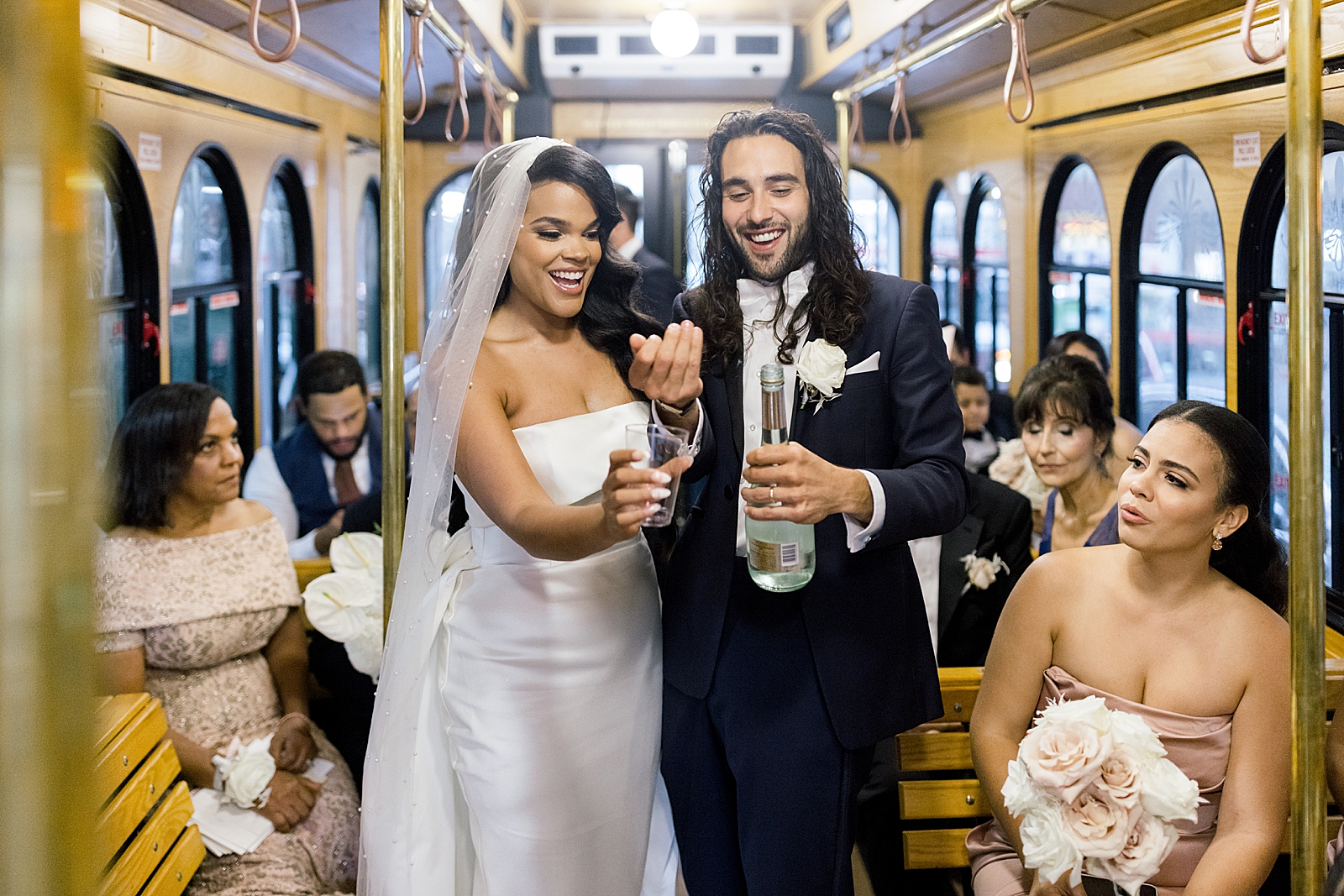 Bride and Groom with bottle of wine in trolley heading to Reception