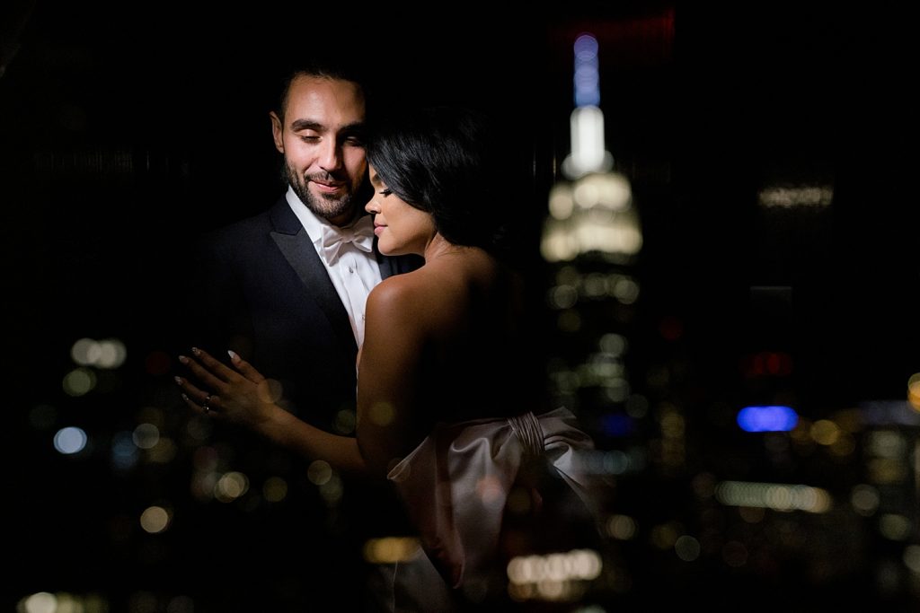 Bride and Groom holding each other with the reflection of empire state building