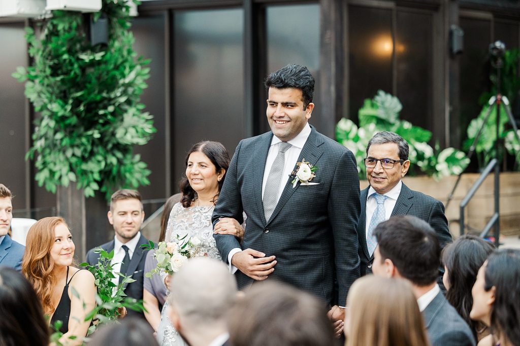 Groom walking down the aisle with parents for Ceremony