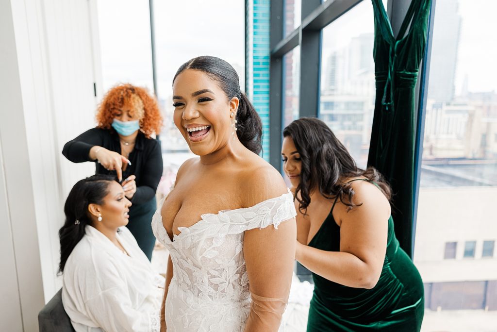 Bride getting ready with help to zip up dress