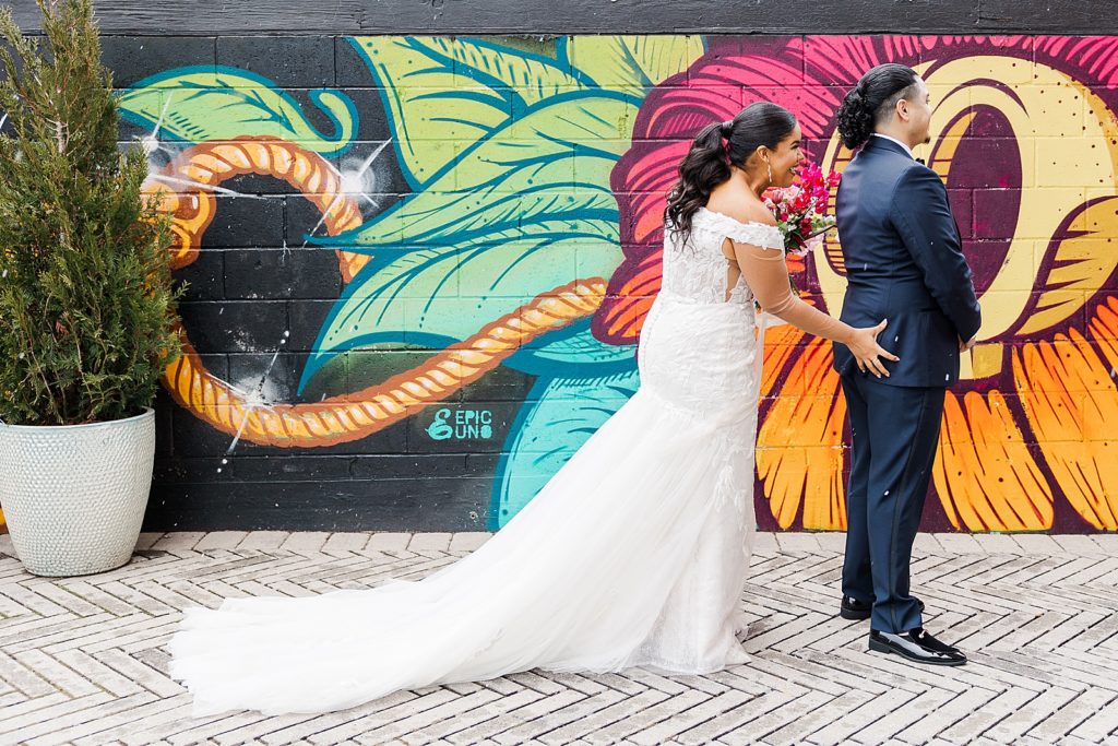 Bride grabbing Groom's ass for first look with cartoon graffiti wall