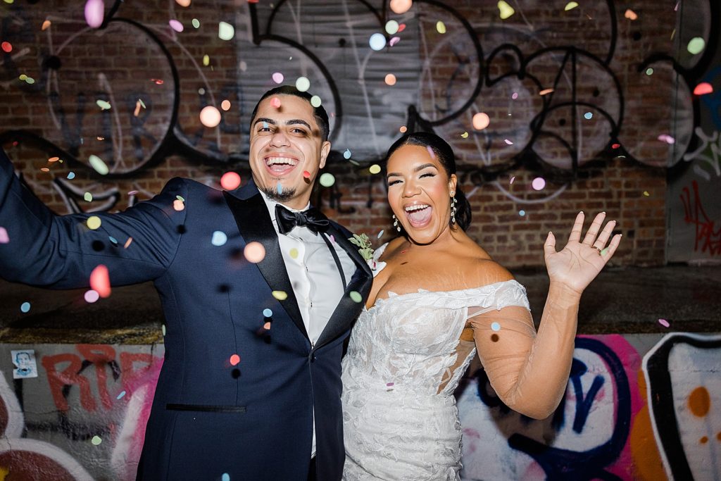 Bride and Groom holding each other inside with Graffiti and Confetti around them