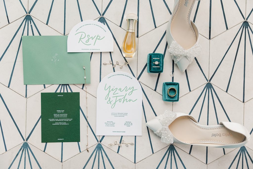 Detail shot of RSVP and save the dates with perfume rings and wedding heels