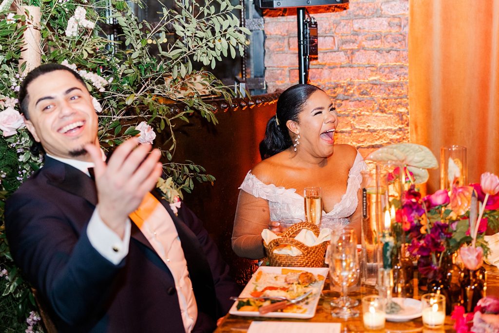 Bride and Groom laughing reacting to speech at sweetheart table