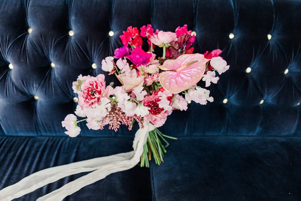 Detail shot of pink wedding bouquet on blue couch