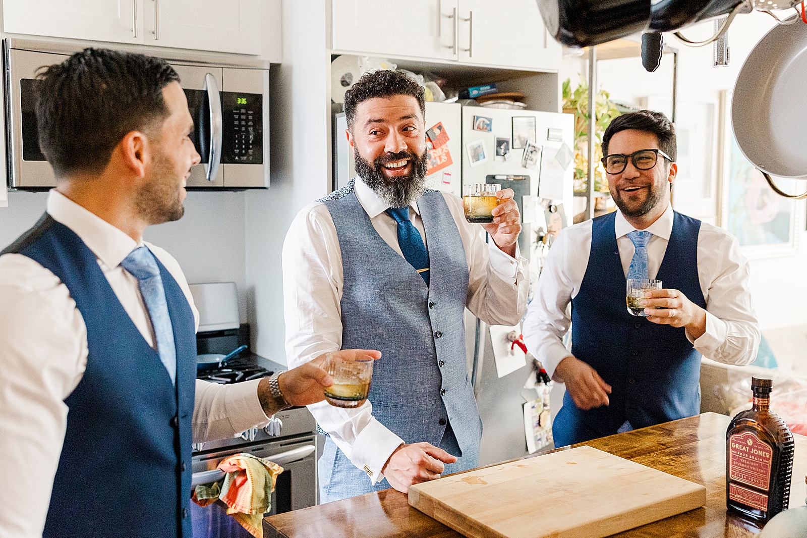 Shot of Eliseo and two of his groomsmen enjoying cocktails in a kitchen.