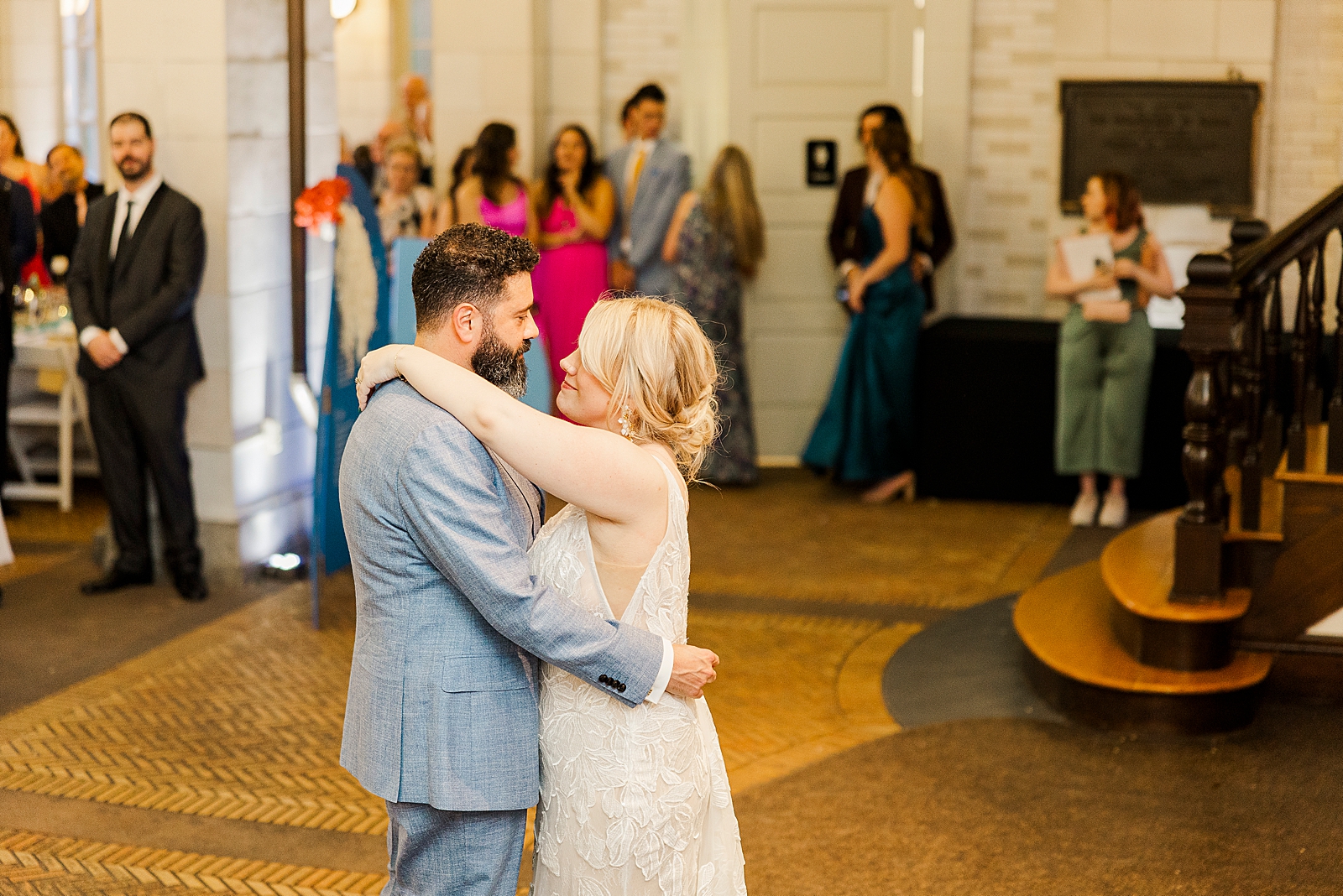 Shot of MK and Eliseo smiling at each other as they dance in front of their guests. 