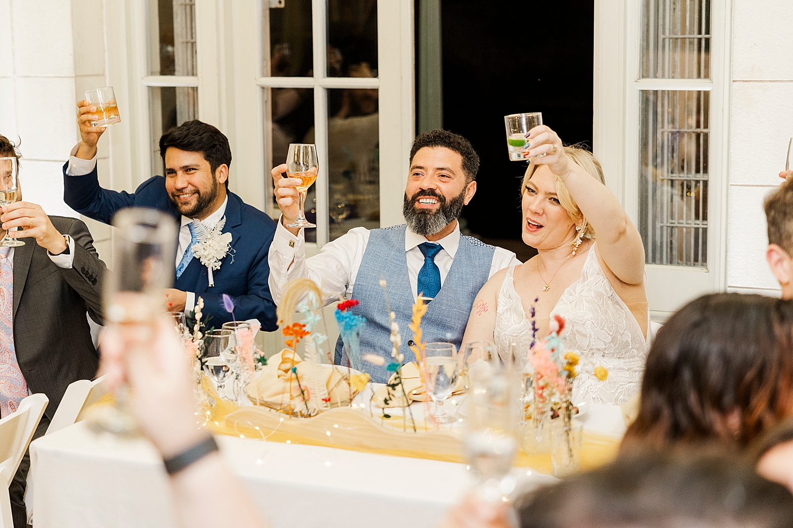 Shot of MK and Eliseo and their guests raising their glasses in toast. 