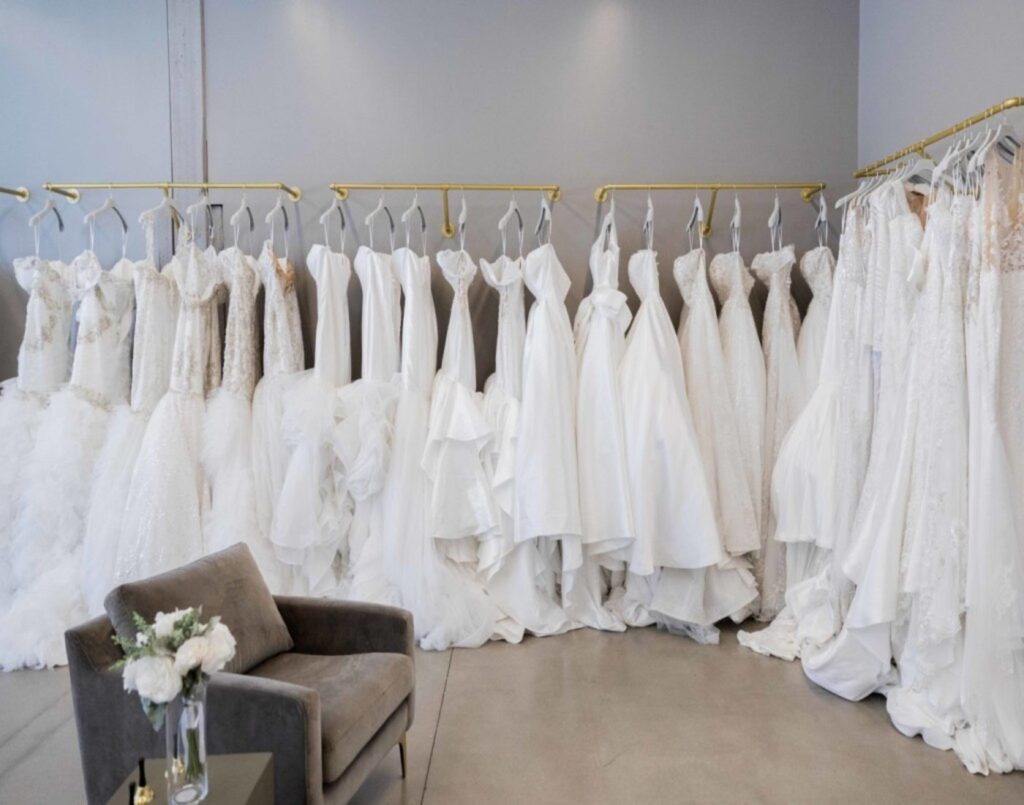 Interior shot of Pantora Bridal, located in Brooklyn, New York. Photo features a long line of wedding dresses on display.