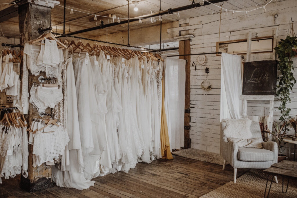 Interior shot of rustic Brooklyn wedding dress shop, Loulette Bride. Features a rack of wedding dresses.