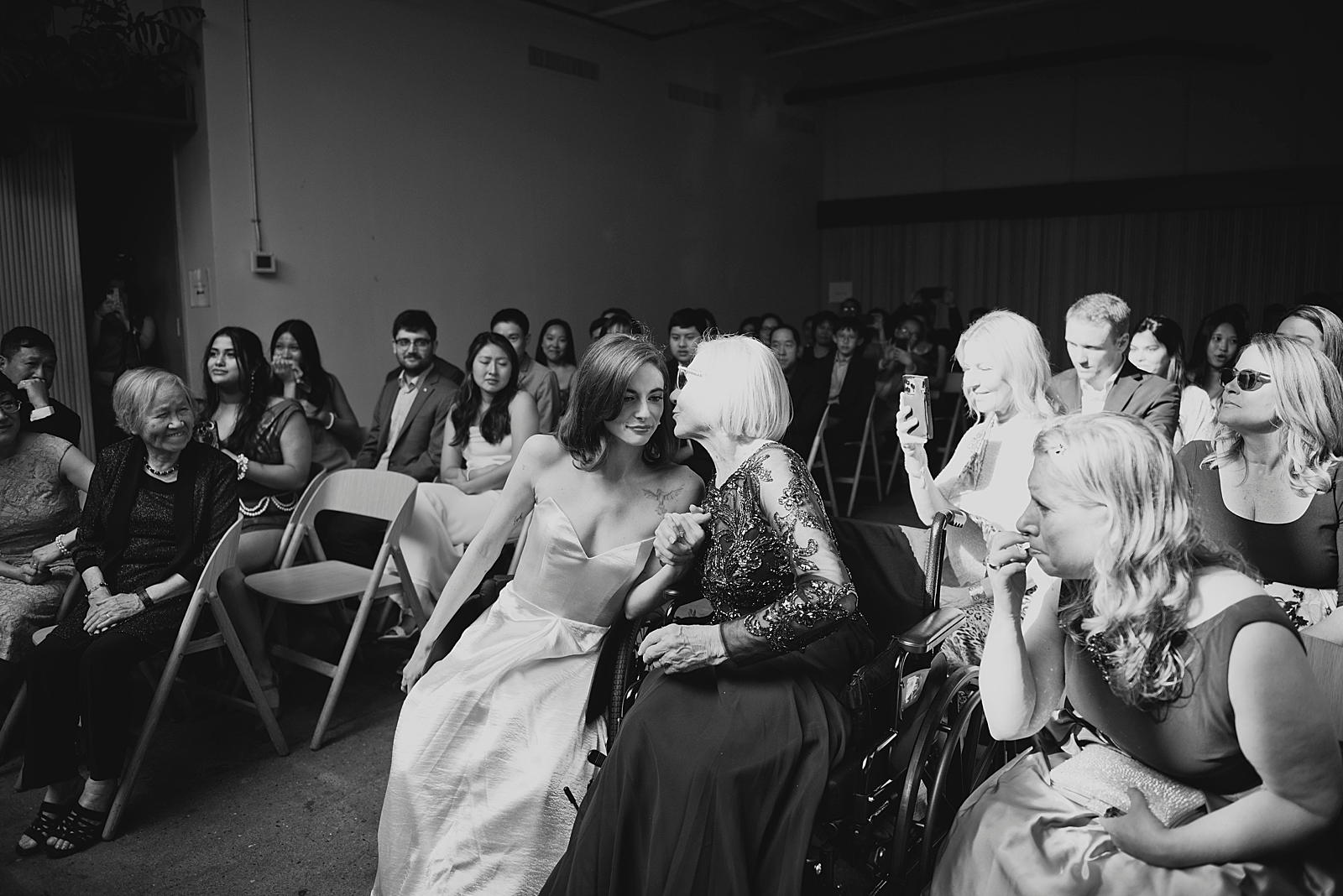 Black and white shot of the bride embracing a guest.