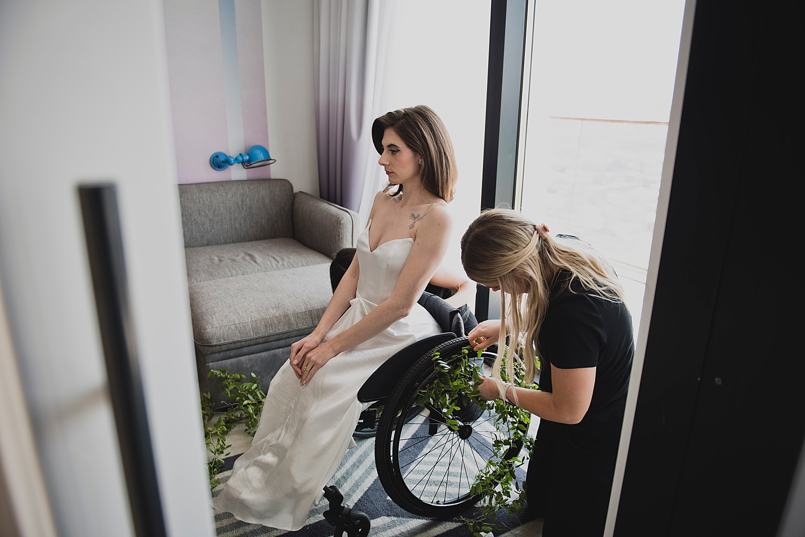 Shot of the bride sitting in her wheelchair as the wheels are decorated with vines. 