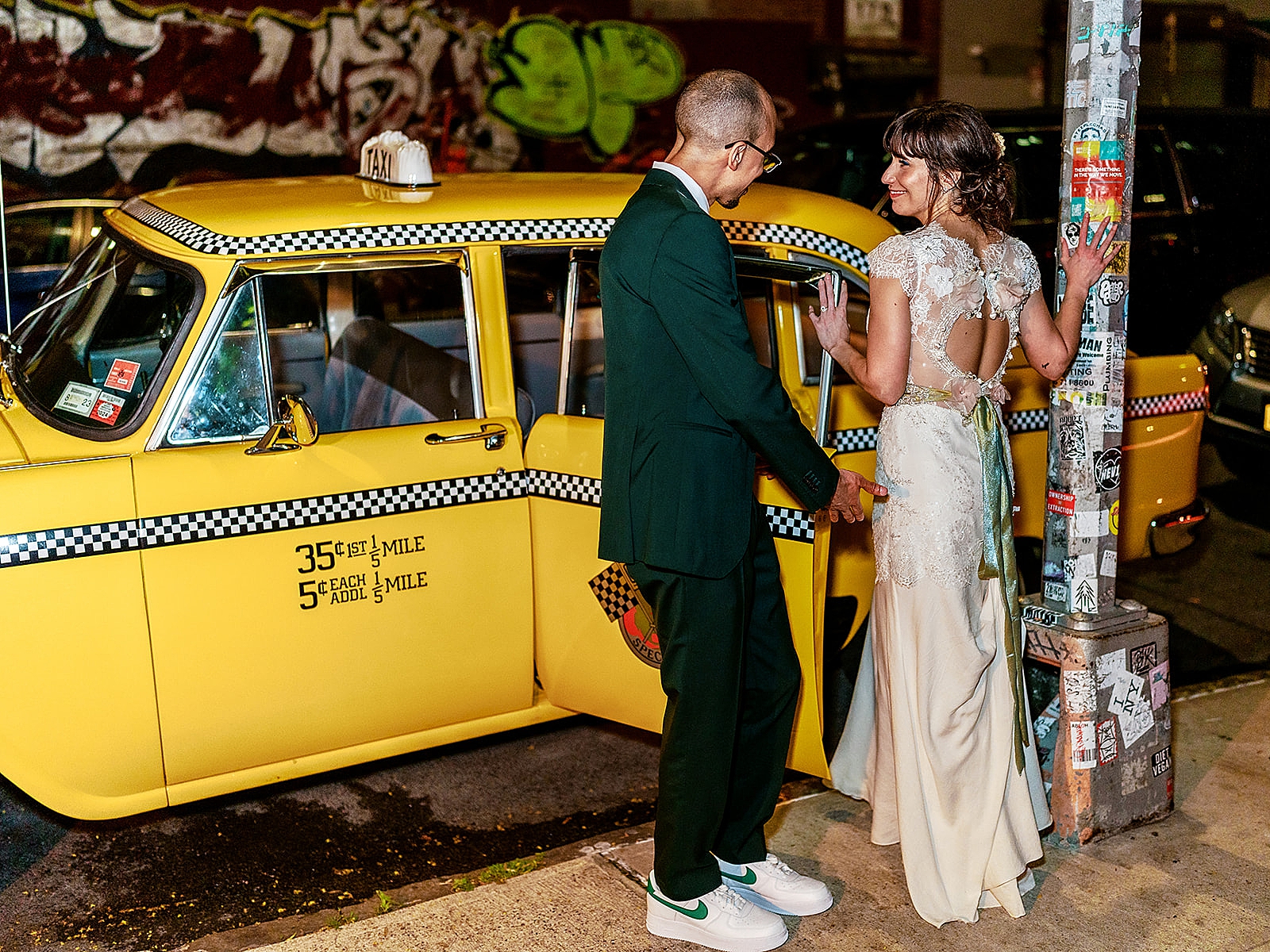 Shot of the groom escorting the bride into a vintage taxicab.