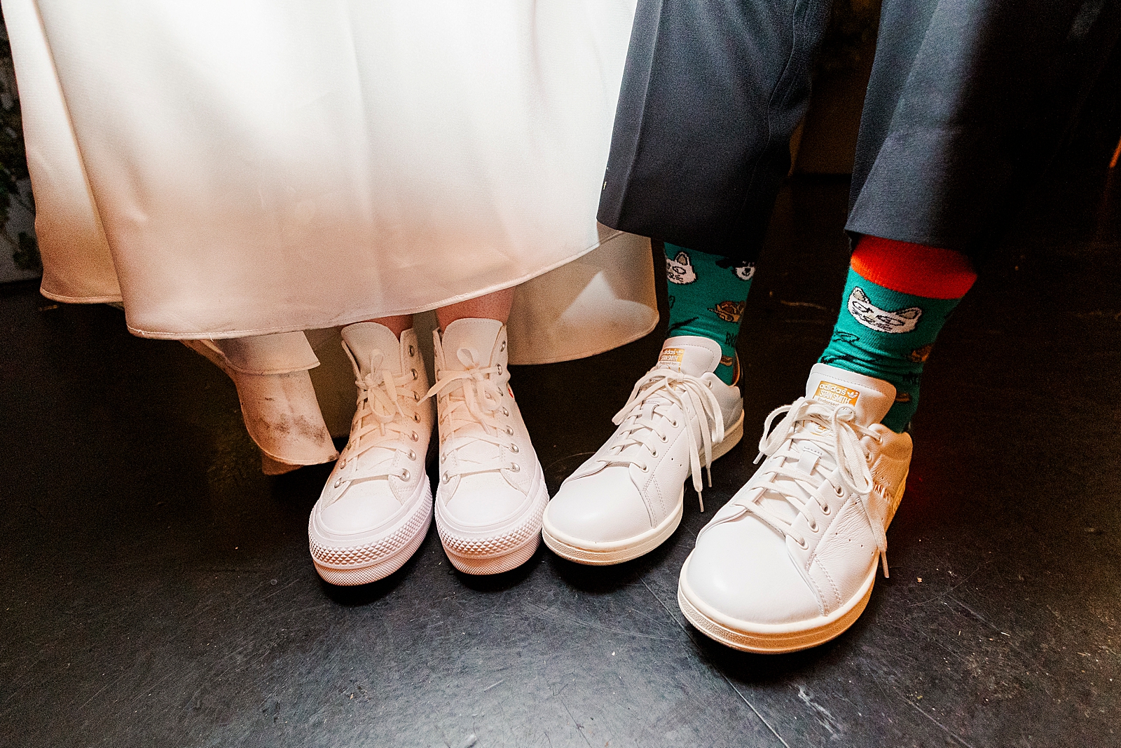 Close up shot of the couple's white sneakers. 